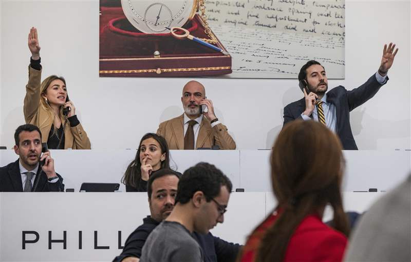 拍賣師在主席臺上舉手。